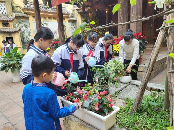 Các em học sinh vui vẻ cùng nhau trồng cây, biểu tượng cho những hình ảnh về bảo vệ môi trường của thế hệ trẻ