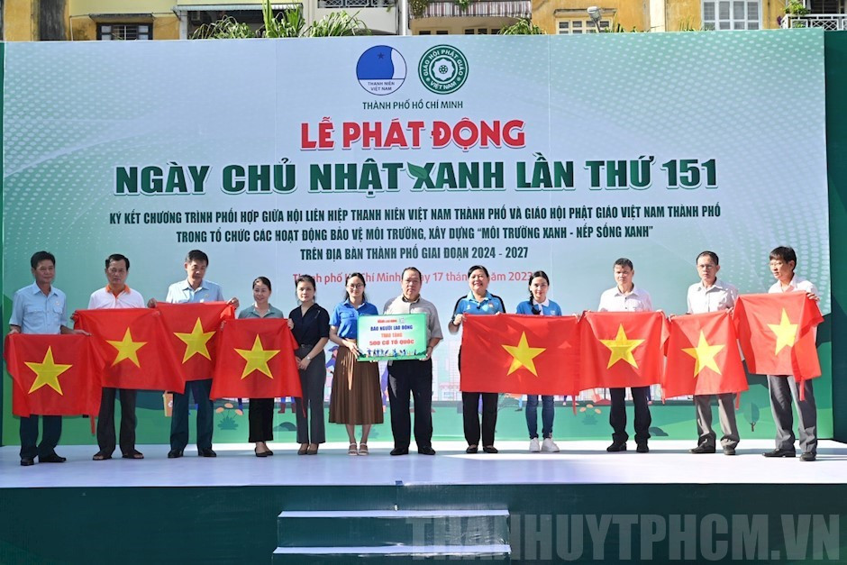 Các tình nguyện viên và đại diện tổ chức bảo vệ môi trường trao cờ Tổ quốc, thể hiện sự gắn kết cộng đồng trong các hoạt động xanh