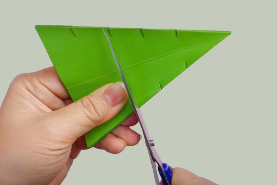 Cắt dọc các đường đều nhau trên tán giấy, bước quan trọng khi làm đồ tái chế bảo vệ môi trường.