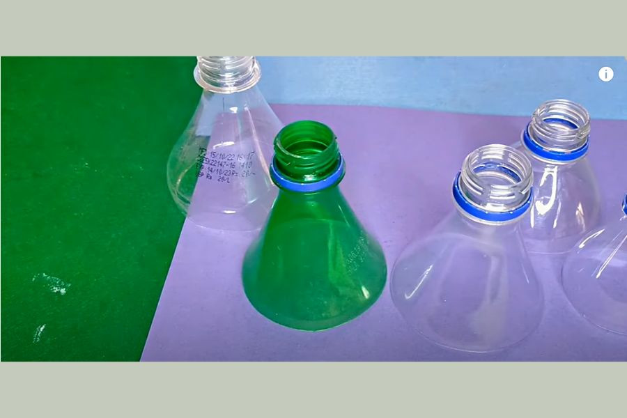 Cắt phần đầu chai nhựa theo kích thước giảm dần, chuẩn bị làm đồ tái chế bảo vệ môi trường.
