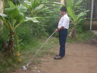 Em Hồ Lâm Hữu Luân sử dụng kẹp nhặt rác vệ sinh sân trường