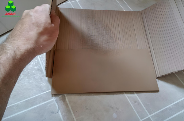 Gấp bìa carton theo các đường gân đã tạo để định hình thùng rác