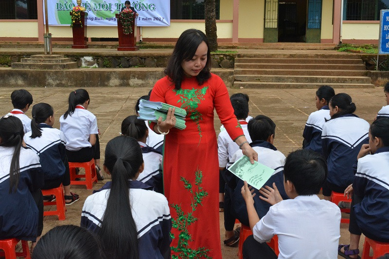 Giáo viên phát tài liệu tuyên truyền bảo vệ môi trường trong sự kiện vẽ đề tài bảo vệ môi trường