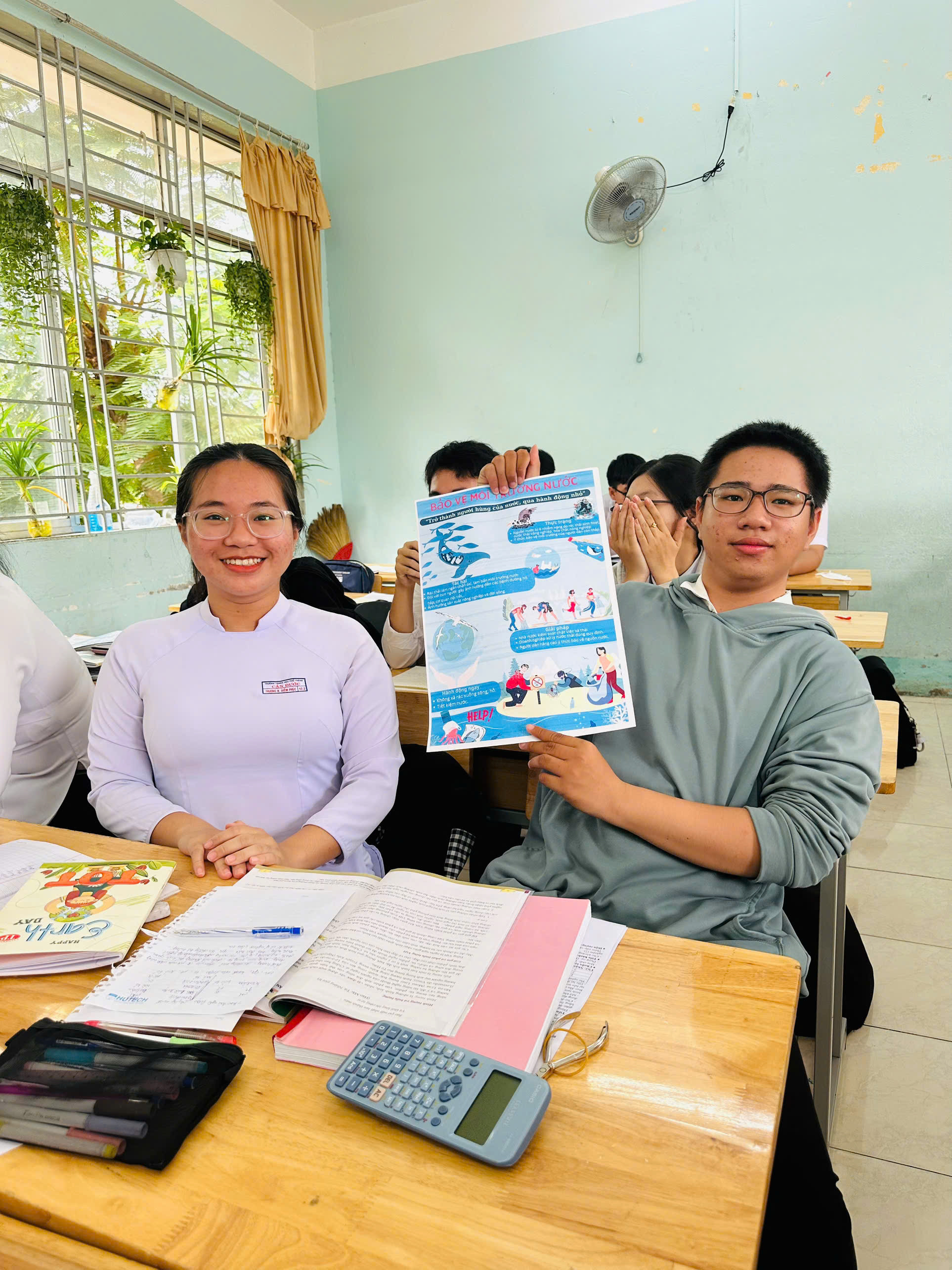 Học sinh đang hợp tác thiết kế poster bảo vệ môi trường với thông điệp giảm rác nhựa, thể hiện tinh thần sáng tạo và làm việc nhóm trong giáo dục môi trường.