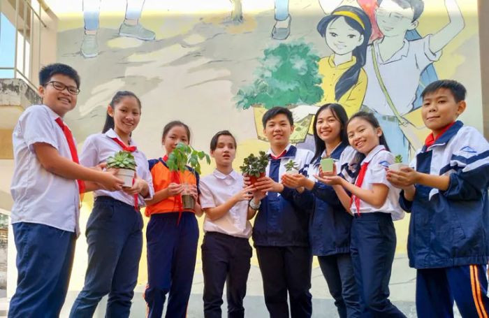 Học sinh dọn dẹp rác xung quanh khu vực xanh, thể hiện ý thức trong những hình ảnh về bảo vệ môi trường