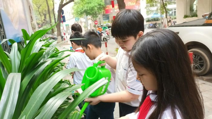 Học sinh tưới cây trong sân trường, một khoảnh khắc thanh bình trong những hình ảnh về bảo vệ môi trường