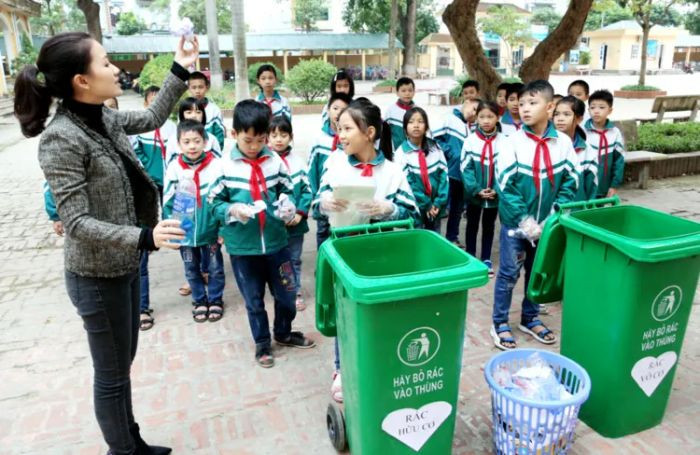 Học sinh với nụ cười khi dọn dẹp, tạo nên những hình ảnh về bảo vệ môi trường đầy tích cực