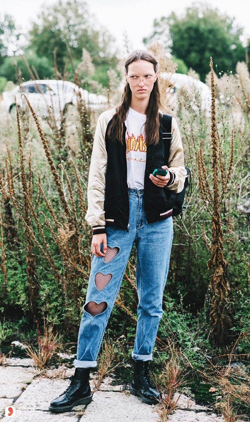 Một cô gái mặc quần jeans rách và áo thun, chiếc quần jeans rách này mang tiềm năng để tái chế thành váy denim với phong cách độc đáo.