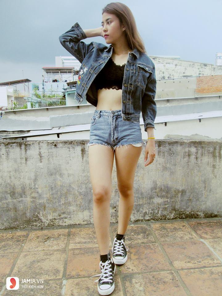 Một cô gái sành điệu mặc quần jeans ngắn và áo khoác jeans, chiếc quần jeans ngắn này có thể được tái chế thành các sản phẩm sáng tạo.