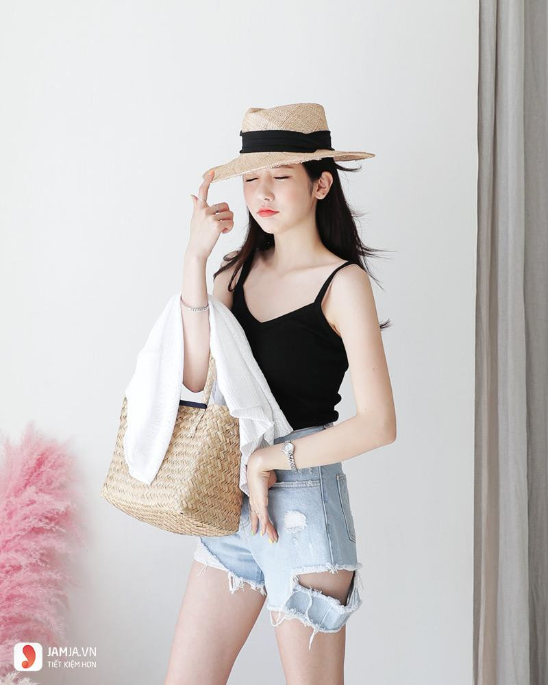 Một cô gái trẻ trung mặc quần jeans ngắn và áo dây, chiếc quần jeans ngắn này là ví dụ về trang phục có thể tái chế thành váy denim hoặc các phụ kiện nhỏ.
