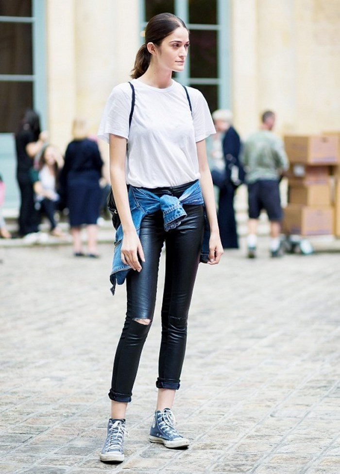 Một cô gái tự tin với áo phông và quần jeans xắn gấu, chiếc quần jeans này là minh chứng cho vật liệu tái chế quần jeans thành váy, góp phần vào thời trang bền vững.
