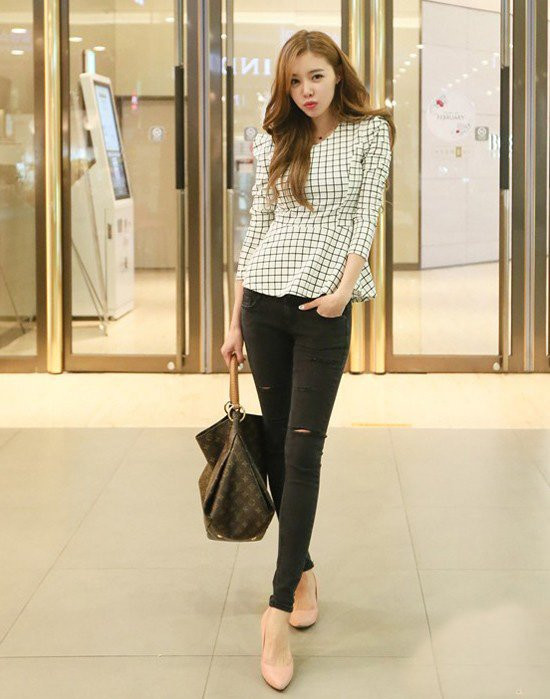 Một cô gái với áo peplum trắng và quần jeans xanh, chiếc quần jeans này đại diện cho kiểu dáng có thể tái chế thành váy chữ A thanh lịch.