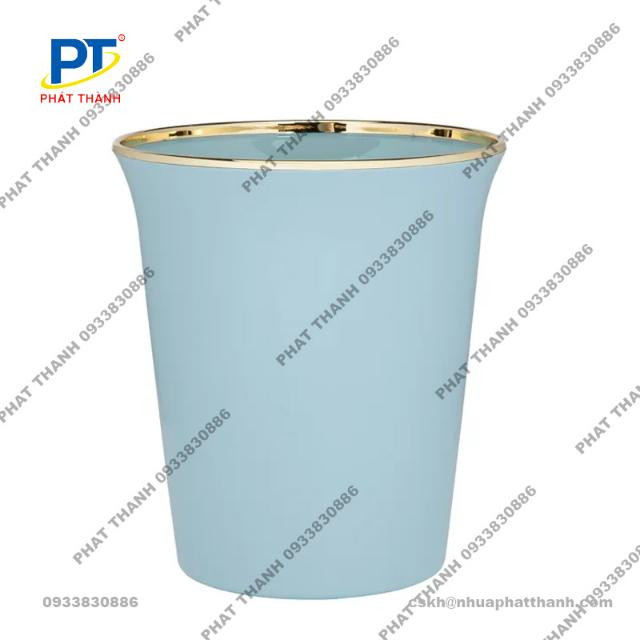 Một thùng rác nhựa không nắp màu xanh xám, nhỏ gọn, đặt trên nền gạch, biểu thị tính tiện lợi và dễ vệ sinh