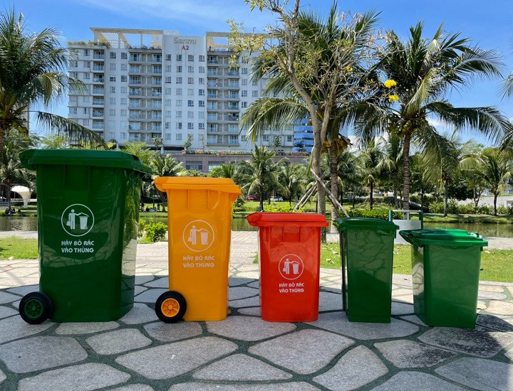 Một thùng rác vô cơ duyên dáng làm từ gỗ và kim loại, được đặt trong không gian xanh, thể hiện sự kết hợp hài hòa giữa chức năng và thẩm mỹ môi trường.