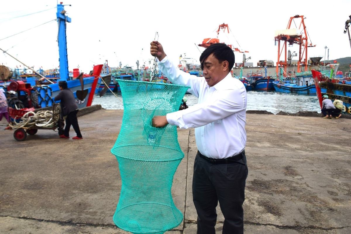 Ông Trần Văn Vinh trao túi đựng rác thải cho ngư dân, một hành động cụ thể trong chiến dịch giảm rác thải nhựa biển, tương tự như tinh thần lan tỏa qua các sản phẩm hoạt hình.